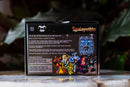 The back of the Ignisynthia box showing text and imagery from the game, standing upright on a reflective surface with a blurred dark green garden background.