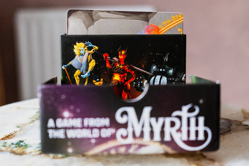 card game open from the side showing the top of the box and characters peaking out